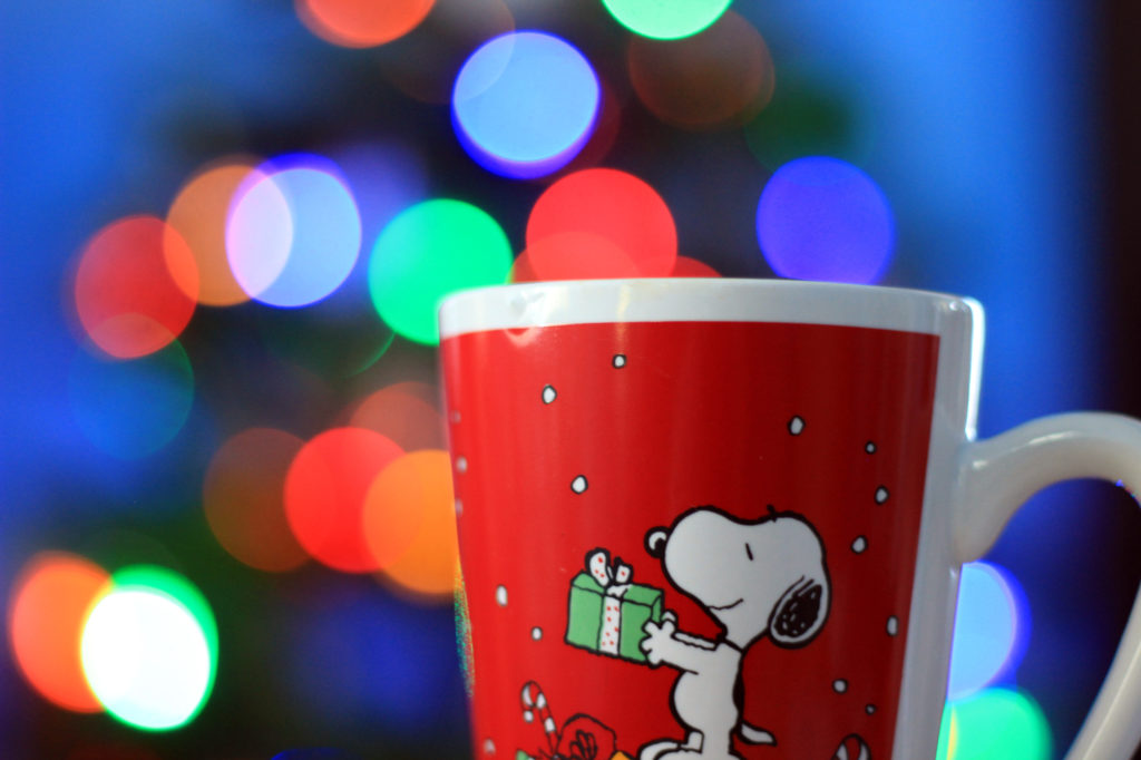 Snoopy coffee mug with the lit tree in the background