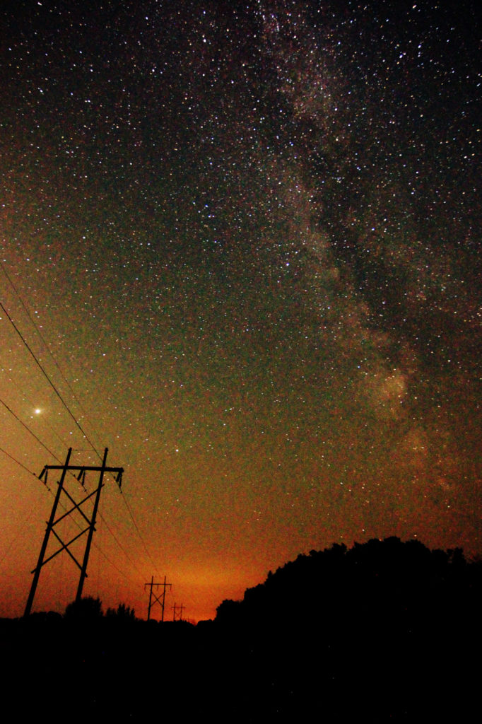The Milky Way above the road and trees