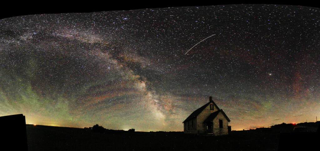Panoramic image of the Milky Way behind an abandoned church