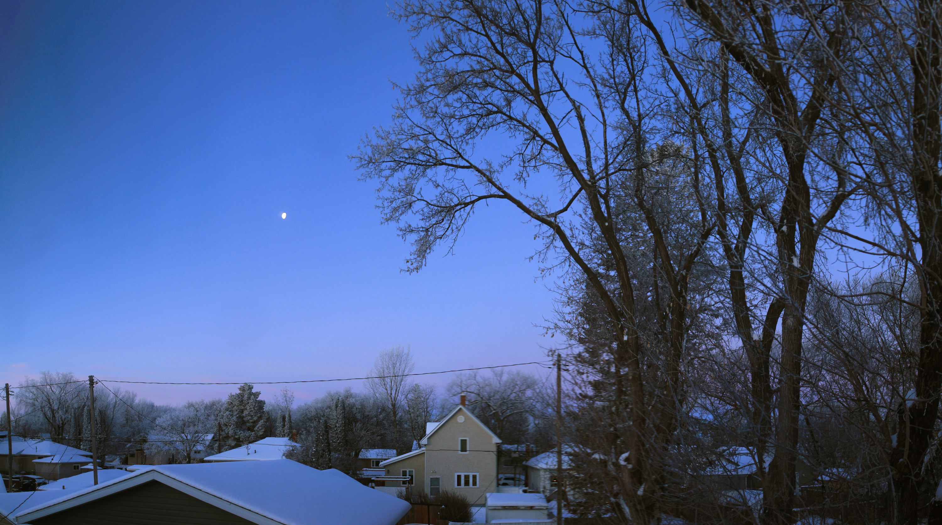 Panorama of the morning skyline from our upstairs window; the gibbous moon is still high in the western sky